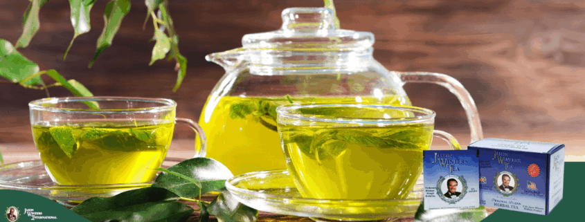Glass teapot and cups filled with vibrant green tea adorned with mint leaves. Tea boxes are displayed on a wooden table with green leaves, creating a fresh, soothing atmosphere.